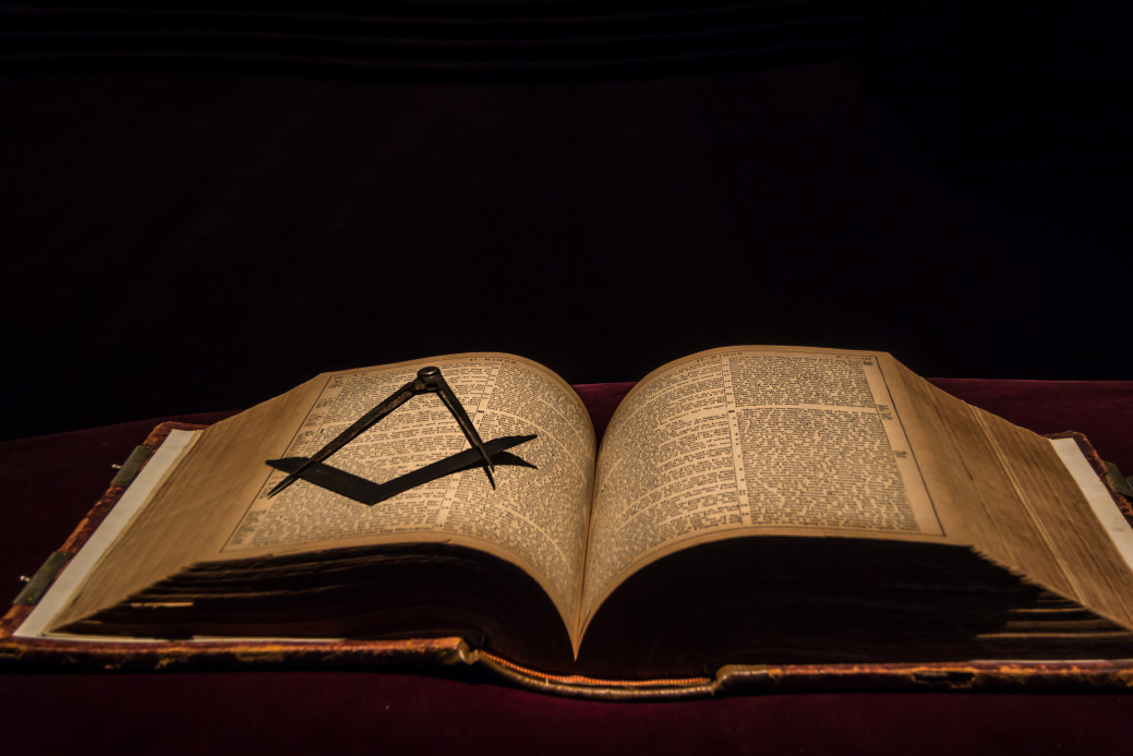 Ancient freemason bible with square and compass on open book